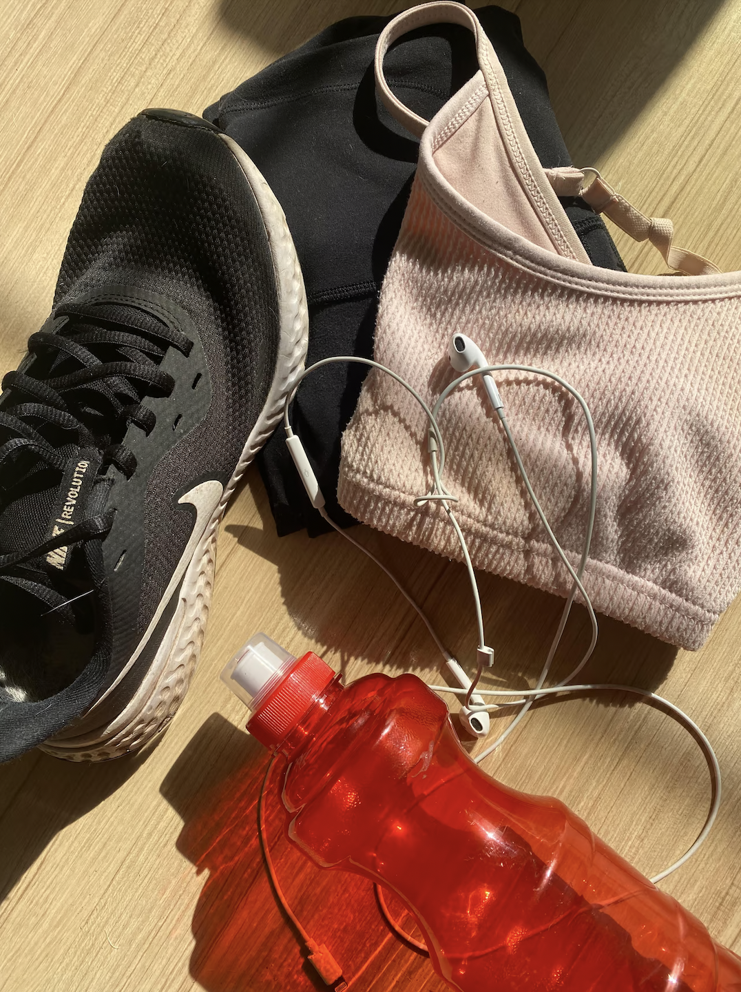 A photo of neatly folded exercise clothes including leggings, a sports bra, and sneakers, symbolising preparation for a 37-week nutrition and fitness weight loss program.