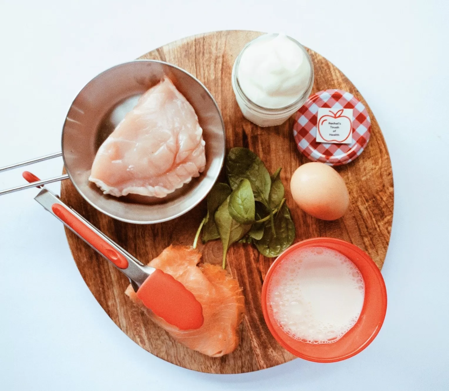 A photo featuring an array of diverse protein sources, including lean meats, fish, eggs, yoghurt, and spinach, symbolising the variety offered in a once-off customised weight loss meal plan.